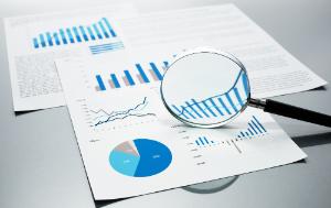 Checking financial reports. Graphs and charts. Documents and magnifying glass on gray reflection background.