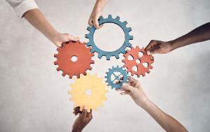 Image depicting 5 hands each holding a gear wheel