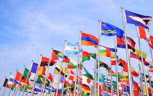 Many flags from around the world with a nice blue sky
